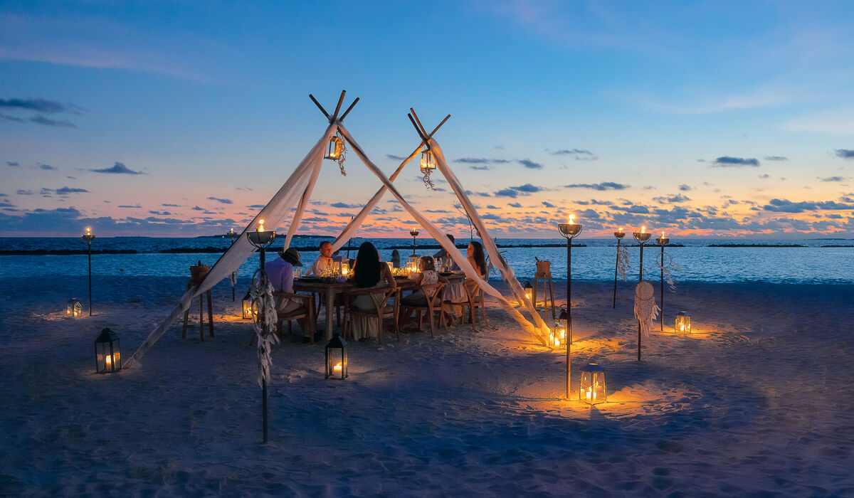 Dining setup on the beach at sunset at The Nautilus Maldives